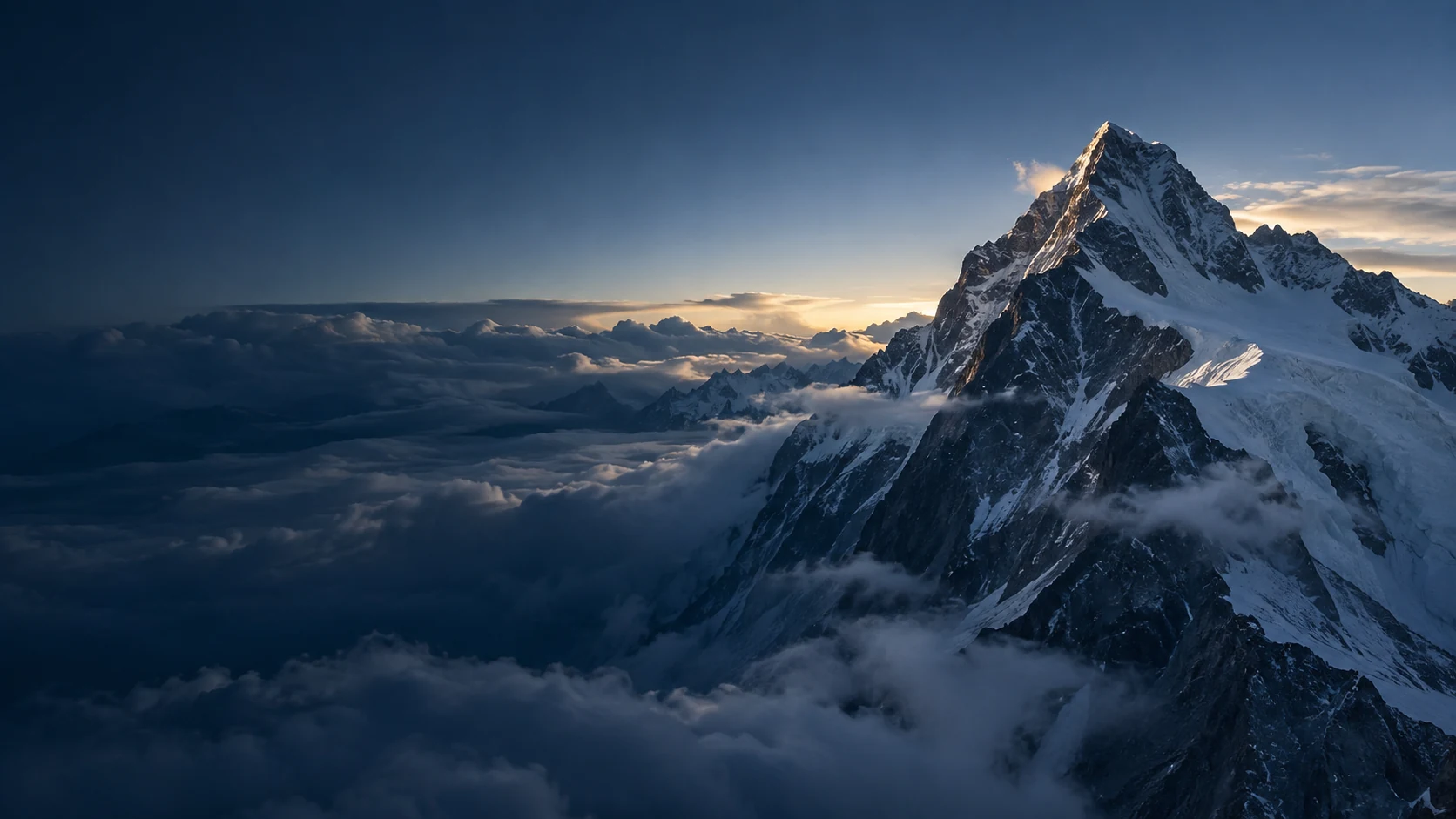 A dramatic alpine summit rising above clouds at sunrise